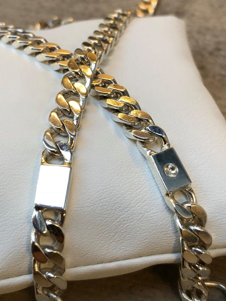 Zilveren sieraad voor as, gourmet collier met open askamer dat ligt op een wit kussentje.