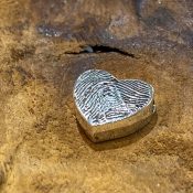 Op deze ashanger in de vorm van een hart is een vingerafdruk van een overleden dierbare geplaatst. Aan de achterkant is een askamer gemaakt.